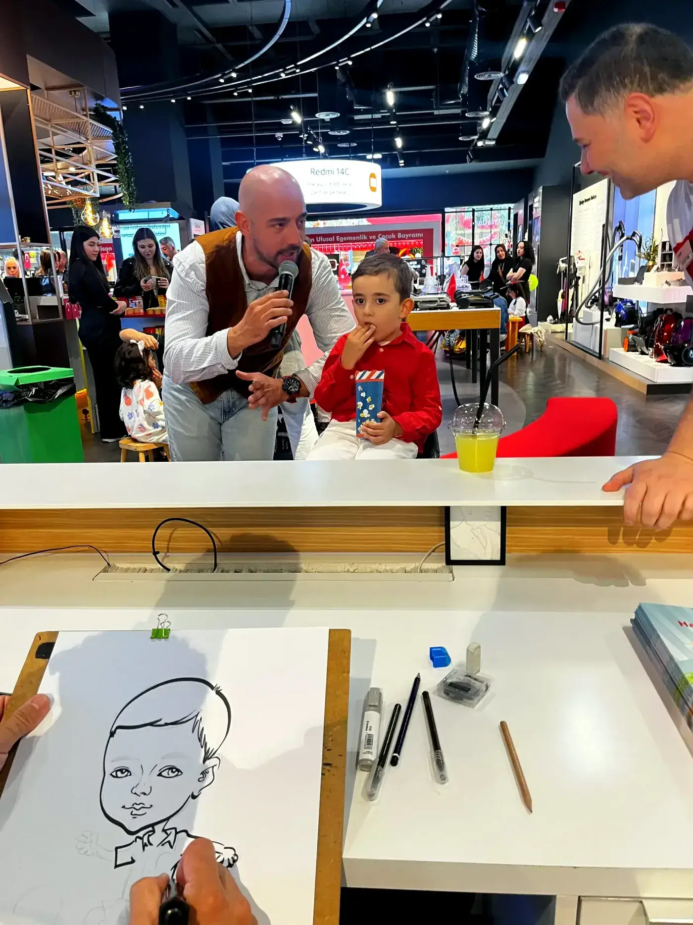 Çocuk etkinliğinde mikrofonlu animatör ve karikatür köşesi