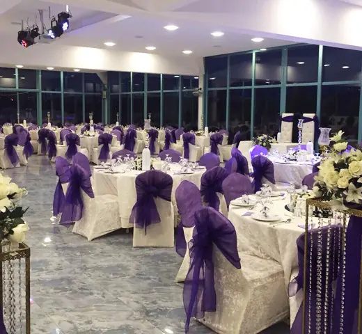 Sandalye giydirmeli ve mor fiyonklu gala salonu
