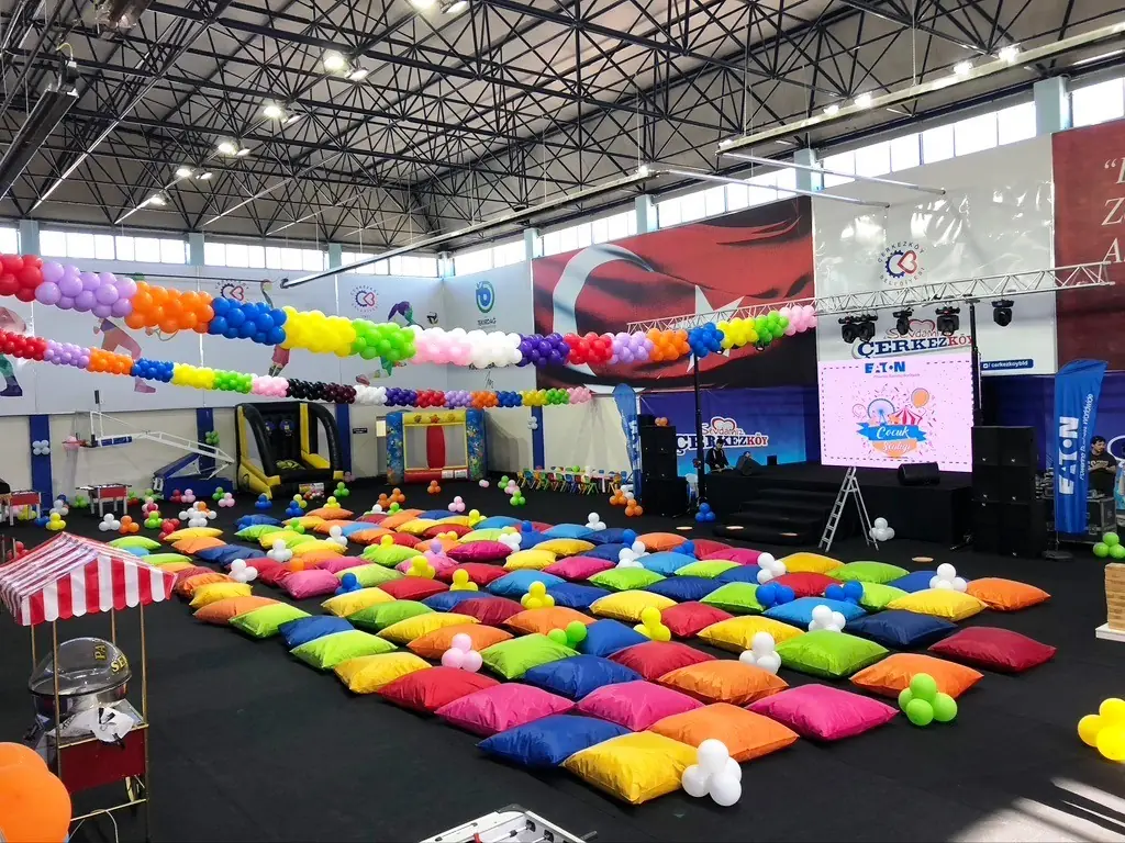 Spor salonunda sahne, balon süsleme ve renkli oturma minderleri